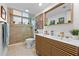 Bright bathroom featuring a modern vanity with double sinks, sleek faucets, and a glass-enclosed shower at 4701 Rambling River Rd, Brandon, FL 33511