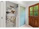 Modern bathroom with marble shower, floating shelves, and a wooden door at 4701 Rambling River Rd, Brandon, FL 33511