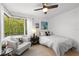 Cozy bedroom with hardwood floors, and a large window looking out on mature landscaping at 4701 Rambling River Rd, Brandon, FL 33511