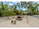 Inviting front yard with a stone fire pit area and surrounding mature trees for a serene setting at 4701 Rambling River Rd, Brandon, FL 33511