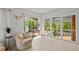 Bright living room featuring walls of windows to exterior deck, white painted floors, and decorative horns at 4701 Rambling River Rd, Brandon, FL 33511