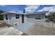 Exterior view of the back of the property showing a concrete patio and an AC unit at 4750 Panorama Ave, Holiday, FL 34690
