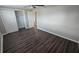 Cozy bedroom with gray wood floors, closet with sliding doors, and neutral paint throughout at 4750 Panorama Ave, Holiday, FL 34690