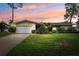 Charming single-story home with a well-manicured lawn, attached garage, and inviting curb appeal at sunset at 5201 Dover Ne St, St Petersburg, FL 33703