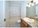 Bright bathroom featuring granite countertop, wood cabinets, and a tiled shower and tub at 5331 Villagebrook Dr, Wesley Chapel, FL 33544