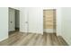 Bedroom with walk-in closet featuring built-in shelving, and light wood laminate floors at 5331 Villagebrook Dr, Wesley Chapel, FL 33544