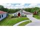 A beautifully landscaped house with a well-manicured lawn, a lake view, and an attached garage at 5331 Villagebrook Dr, Wesley Chapel, FL 33544