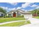 Inviting single-story home with a manicured lawn and garden beds, close to adjacent screened porch at 5331 Villagebrook Dr, Wesley Chapel, FL 33544