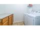 Laundry room features wood cabinets, counter space, newer machines, and storage space at 5331 Villagebrook Dr, Wesley Chapel, FL 33544