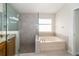 Main bathroom with a soaking tub and a glass-enclosed shower at 5331 Villagebrook Dr, Wesley Chapel, FL 33544
