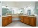 Main bathroom with dual sinks, granite countertops, and large mirrors at 5331 Villagebrook Dr, Wesley Chapel, FL 33544
