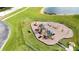 Aerial view of a community playground with swings, slides, and picnic tables near a beautiful lake at 5331 Villagebrook Dr, Wesley Chapel, FL 33544