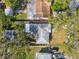 Aerial view of a home with a grey roof and surrounding greenery, including other residential properties at 610 N Woodlynne Ave, Tampa, FL 33609