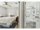 Cozy bedroom with ceiling fan adjacent to a bathroom with decorative tile flooring at 610 N Woodlynne Ave, Tampa, FL 33609