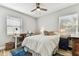 Well lit bedroom with ceiling fan, desk area, blue rug, and two windows at 610 N Woodlynne Ave, Tampa, FL 33609