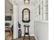 Welcoming foyer with decorative mirror, a bookshelf, and hardwood floors at 610 N Woodlynne Ave, Tampa, FL 33609