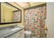 Bathroom featuring a floral shower curtain, granite sink and a large mirror at 7501 Greystone Dr, Hudson, FL 34667