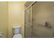 Bathroom features toilet, frosted shower with metal sliding door, and yellow walls at 7501 Greystone Dr, Hudson, FL 34667