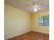 Bedroom with yellow walls, light wood floors, and a ceiling fan at 7501 Greystone Dr, Hudson, FL 34667
