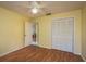 Bedroom with yellow walls, wood floors, closet, and ceiling fan at 7501 Greystone Dr, Hudson, FL 34667