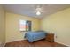 Cozy bedroom with warm yellow walls, a ceiling fan, and a window bringing in natural light at 7501 Greystone Dr, Hudson, FL 34667
