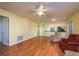 Open living room area with hardwood floors, ceiling fan and view of the kitchen at 7501 Greystone Dr, Hudson, FL 34667