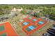 Aerial view of pickleball courts surrounded by lush greenery at 7501 Greystone Dr, Hudson, FL 34667