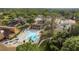 Aerial view of community pool and tennis courts surrounded by lush greenery at 7501 Greystone Dr, Hudson, FL 34667