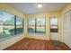 Light-filled sunroom with lots of windows, wood floors, and a door to the outside at 7501 Greystone Dr, Hudson, FL 34667