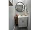 Bathroom features a modern sink, round mirror, and a decorative wicker basket organizer at 9007 Pebble Creek Dr # 9007, Tampa, FL 33647