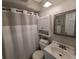 A well-lit bathroom with a shower featuring a shower curtain, a modern vanity, and a mirrored medicine cabinet at 9007 Pebble Creek Dr # 9007, Tampa, FL 33647