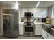Bright kitchen featuring stainless steel appliances, white cabinets, and light gray floors at 9007 Pebble Creek Dr # 9007, Tampa, FL 33647