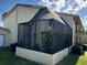 A fenced screened patio with neutral walls provides exterior shade, greenery, and access to the home's amenities and views at 9007 Pebble Creek Dr # 9007, Tampa, FL 33647