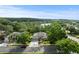 Expansive aerial view of home surrounded by lush landscaping, adjacent to a serene lake in a quiet neighborhood at 1003 Berkshire Ln, Tarpon Springs, FL 34688