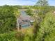 An aerial view highlights the home's screened-in pool and its tranquil backyard setting with mature tree coverage at 1003 Berkshire Ln, Tarpon Springs, FL 34688