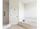 Bathroom featuring walk-in shower and jetted soaking tub with marble surround at 1003 Berkshire Ln, Tarpon Springs, FL 34688