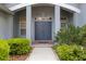 Elegant front entrance with double doors, flanked by lush greenery and classic architectural details at 1003 Berkshire Ln, Tarpon Springs, FL 34688