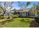 Charming single-story home with gray exterior, manicured lawn, and lush landscaping at 1003 Berkshire Ln, Tarpon Springs, FL 34688