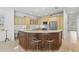 Bright kitchen with stainless steel appliances, elegant light-toned cabinetry, and an oversized island with seating at 1003 Berkshire Ln, Tarpon Springs, FL 34688