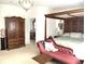 Elegant main bedroom featuring a four-poster bed, armoire, chaise lounge, and access to an ensuite bathroom at 1003 Berkshire Ln, Tarpon Springs, FL 34688