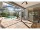 Inviting screened-in pool area featuring a spacious deck, ceiling fan, and seamless access to the interior living space at 1003 Berkshire Ln, Tarpon Springs, FL 34688