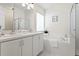 Bright bathroom featuring a double sink vanity, tub, and glass-enclosed shower at 10339 Lightner Bridge Dr, Tampa, FL 33626