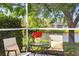 Relaxing screened-in patio with cozy seating, a view of the pond, and beautiful landscaping at 10339 Lightner Bridge Dr, Tampa, FL 33626