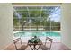 Seating area overlooking a pool with screened-in enclosure and waterfront views at 10339 Lightner Bridge Dr, Tampa, FL 33626
