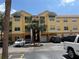 Attractive three-story condo building with a tile roof, green awnings, and palm trees at 10764 70Th Ave # 4302, Seminole, FL 33772