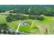 An aerial view of a stunning white modern farmhouse with a dark roof, surrounded by lush greenery and mature trees at 111 Alafia Estates Ln, Plant City, FL 33567