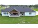 Stunning exterior with spacious backyard, covered patio, and white exterior at 111 Alafia Estates Ln, Plant City, FL 33567