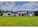 Expansive single-story home featuring a sprawling green lawn and elegant white exterior, creating a welcoming curb appeal at 111 Alafia Estates Ln, Plant City, FL 33567