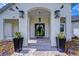 Inviting front entrance featuring brick pavers, black planters, and a black framed glass front door at 111 Alafia Estates Ln, Plant City, FL 33567