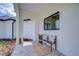 Inviting front porch featuring a cozy bench with decorative pillows, brick floors, and ample natural light at 111 Alafia Estates Ln, Plant City, FL 33567